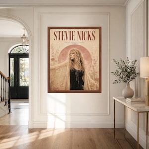 May include: A framed wall art print featuring a portrait of Stevie Nicks with the text STEVIE NICKS and BELLA DONNA DREAMS. The artwork displays a person with long wavy hair wearing a lace shawl over a black top, set against a large pink moon.