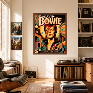 May include: A framed wall art print featuring a stylized portrait of David Bowie with a red lightning bolt across the face, surrounded by colorful cosmic graphics, planets, and the text DAVID BOWIE STARMAN REBEL ICON in a dark brown wooden frame.