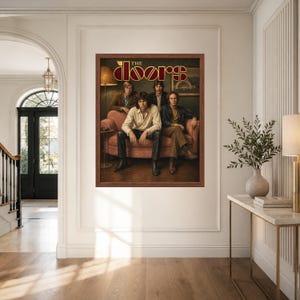 May include: A framed rectangular wall art print featuring the band The Doors. The image shows four individuals sitting on a pink sofa in a dimly lit room. The text THE DOORS is printed in a stylized gold and red font at the top of the artwork.