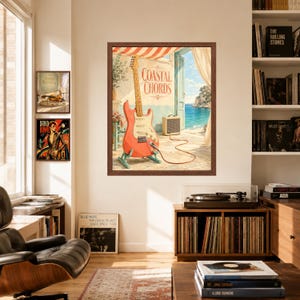 May include: A framed wall art print titled Coastal Chords featuring a coral electric guitar on a stand connected to a small amplifier. The scene depicts an open doorway overlooking a blue sea with a striped awning and light-coloured stone walls.
