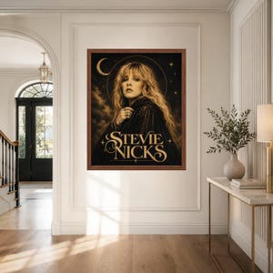 Puede incluir: Una l&aacute;mina de arte mural enmarcada con un retrato de Stevie Nicks de pelo rubio largo, vestida con una capa oscura. El fondo es negro con una luna creciente y estrellas. El texto STEVIE NICKS est&aacute; impreso en una fuente dorada en la parte inferior.