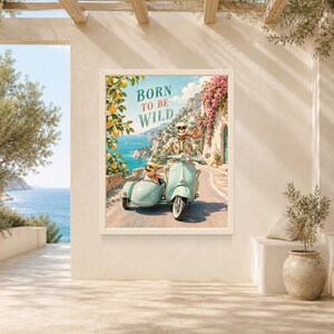 May include: A framed wall art print featuring a skeleton wearing sunglasses and a floral shirt riding a light blue scooter with a sidecar containing a small dog. The text BORN TO BE WILD is printed above. The scene depicts a coastal road with lemon trees and pink flowers.