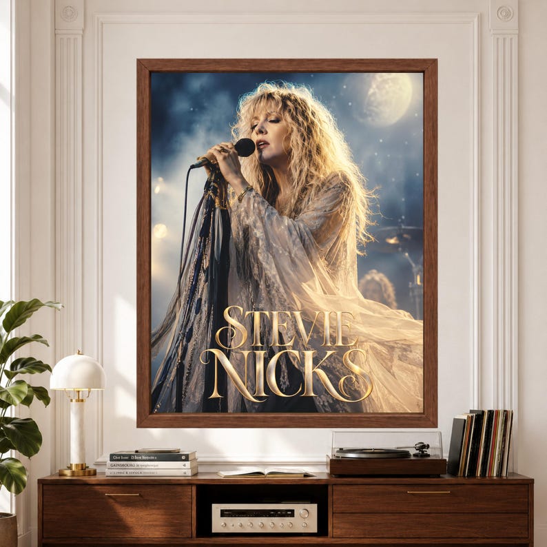 Framed Stevie Nicks wall art showing a female rock singer performing at a microphone in flowing cream lace beneath a pale moon with smoky blue stage lighting and ornate gold lettering.
