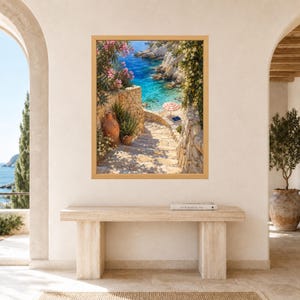 Peut inclure: Une impression d'art encadr&eacute;e repr&eacute;sentant une sc&egrave;ne c&ocirc;ti&egrave;re m&eacute;diterran&eacute;enne avec un escalier en pierre menant &agrave; une mer turquoise. L'image montre un vase en terre cuite, des lauriers roses et un petit parasol ray&eacute; sur le rivage.