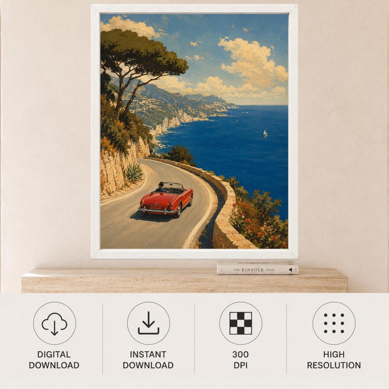 May include: A framed wall art print depicting a red vintage convertible driving along a winding coastal road overlooking a deep blue sea. The scene features a rocky cliffside with green trees, a clear sky with white clouds, and a distant sailboat.