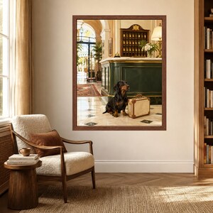 May include: A framed wall art print depicting a hotel lobby scene with a black and tan dachshund sitting on a marble floor next to a vintage-style beige suitcase. The background shows a dark green reception desk, a key rack, and a lamp.