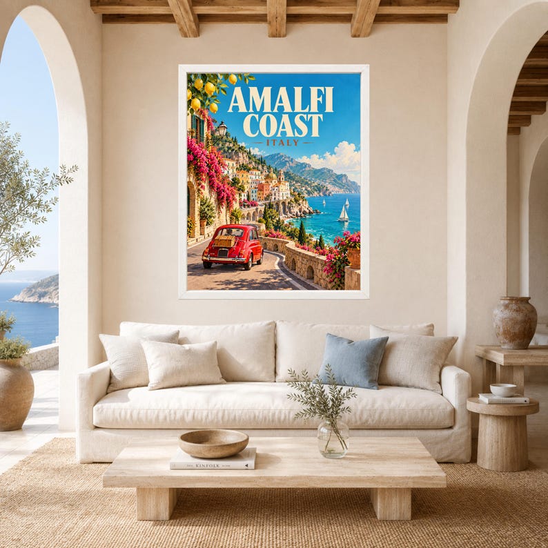 May include: A framed wall art print featuring a travel poster of the Amalfi Coast, Italy. The image displays a red vintage car on a coastal road, vibrant pink flowers, lemon branches, blue sea, and the text AMALFI COAST ITALY in white.