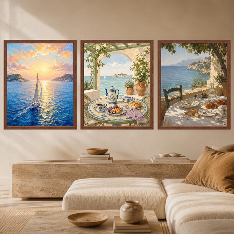 May include: A set of three framed wall art prints. The left print shows a sailboat on blue water at sunset. The middle print depicts a table with a teapot, cups, and fruit on a terrace. The right print shows a table set for a meal by the sea.