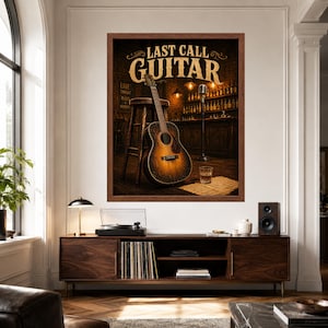 May include: A framed wall art print titled LAST CALL GUITAR featuring an acoustic guitar leaning against a wooden stool in a dimly lit bar setting with a microphone stand, a glass of whiskey, and shelves of bottles in the background.
