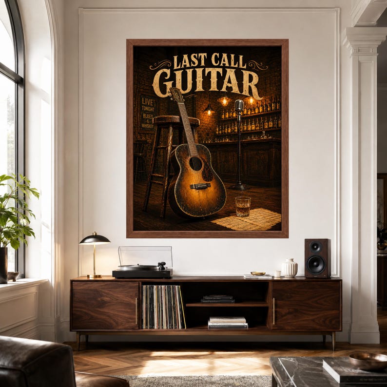 May include: A framed wall art print titled LAST CALL GUITAR featuring an acoustic guitar leaning against a wooden stool in a dimly lit bar setting with a microphone stand, a glass of whiskey, and shelves of bottles in the background.