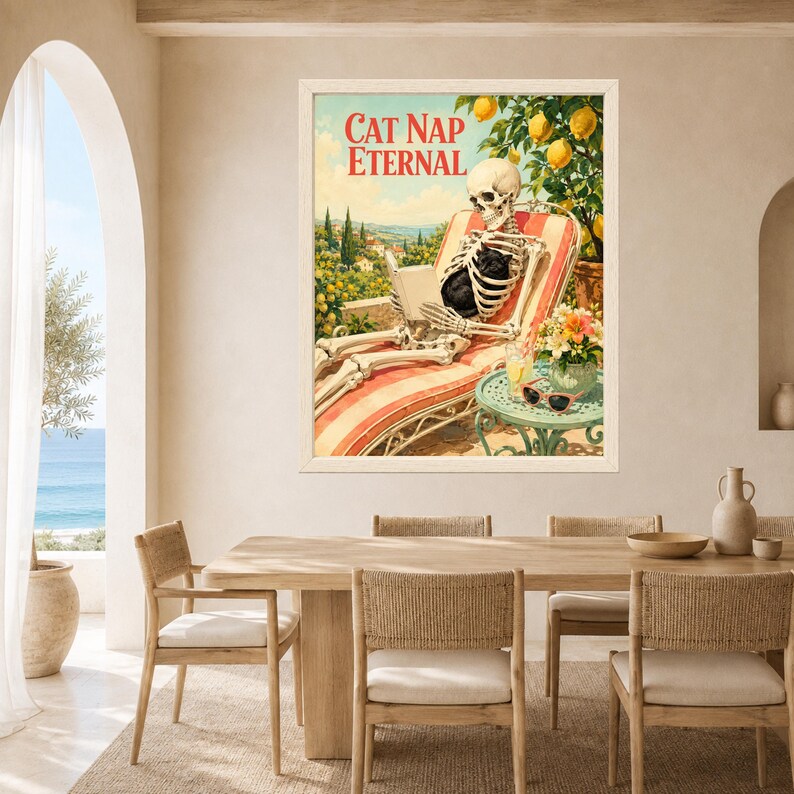 May include: A framed wall art print titled CAT NAP ETERNAL featuring a skeleton lounging on a red and white striped chair, reading a book with a black cat on its lap. A lemon tree, a small table with a drink, and sunglasses are visible.
