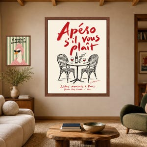 May include: A framed wall art print featuring a bistro table with two chairs, a wine bottle, and two glasses. The text reads Ap&eacute;ro s'il vous pla&icirc;t, Libre moments &agrave; Paris, and Bistrot Chez Lucette 18h. A second smaller print shows a duck in a towel.