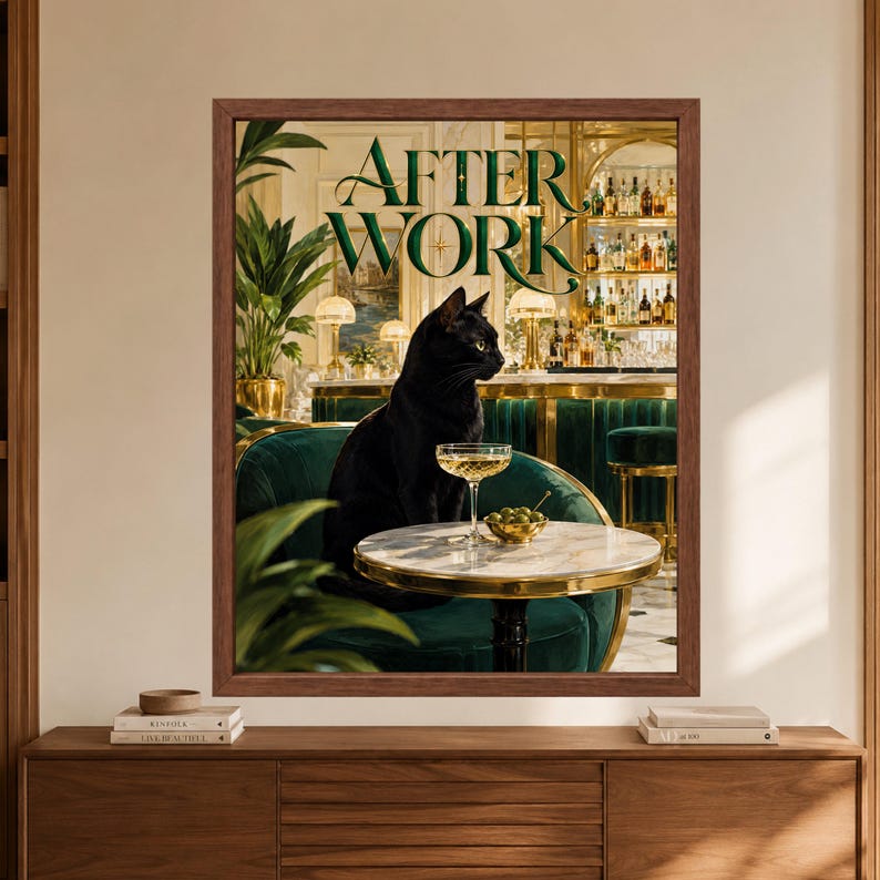 Framed black cat cocktail wall art showing a black cat seated in a green velvet Art Deco bar beside a coupe glass and olives, with large After Work lettering above the scene.