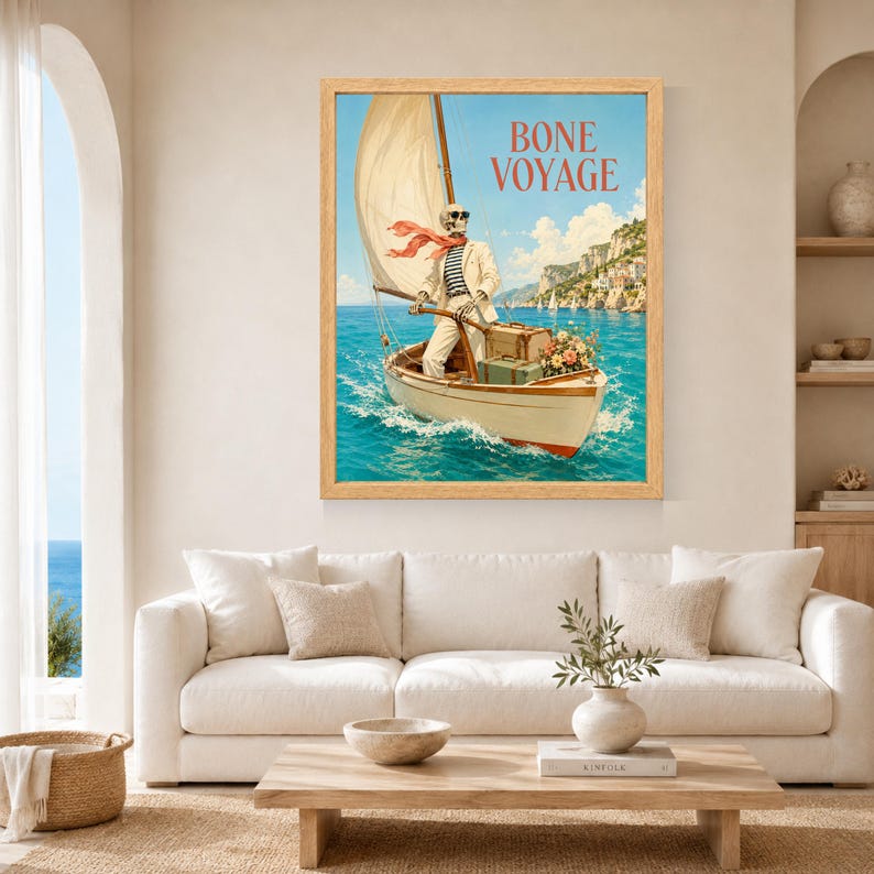 May include: A framed wall art print featuring a skeleton wearing sunglasses, a white suit, and a red scarf, steering a sailboat on blue water. The text BONE VOYAGE is printed in red at the top. The boat carries two suitcases and a bouquet of flowers.
