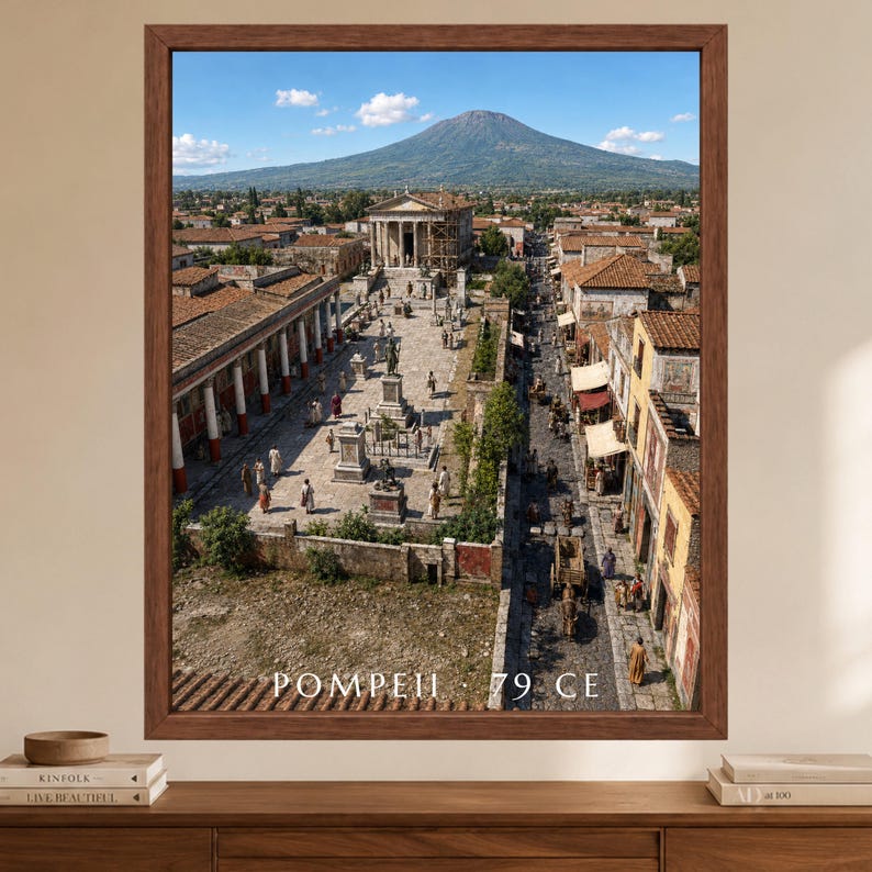 K&ouml;nnte beinhalten: Ein gerahmter Wandkunstdruck mit einer Luftaufnahme der antiken Stadt Pompeji vor dem Vesuv. Die Szene zeigt Steingeb&auml;ude, einen zentralen Platz mit Statuen und umhergehende Personen. Der Text lautet POMPEII 79 CE.