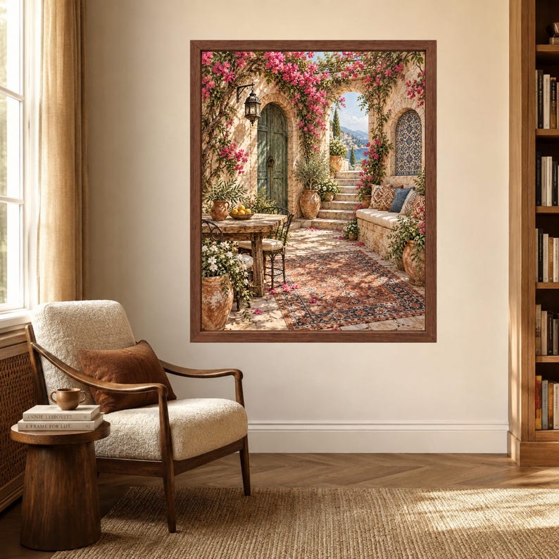 May include: A framed wall art print depicting a Mediterranean patio scene with a stone table, chairs, a built-in bench, and terracotta pots filled with pink bougainvillea flowers. The scene features a patterned rug, a lantern, and an arched doorway.