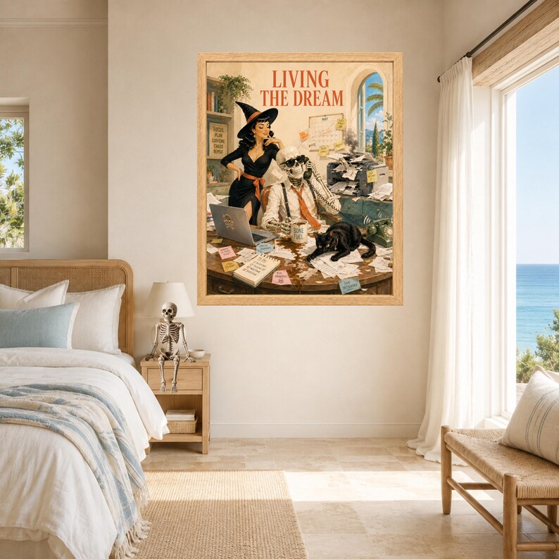 May include: A framed wall art print titled LIVING THE DREAM featuring a retro-style illustration of a witch and a skeleton working at a cluttered office desk with a black cat, a laptop, a printer, and various scattered papers and sticky notes.