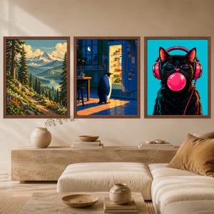 May include: Three framed wall art prints displayed in a row. The left print shows a mountain landscape with pine trees and a lake. The center print depicts a penguin standing before an open refrigerator in a kitchen. The right print features a black cat wearing pink headphones and blowing a pink bubble.