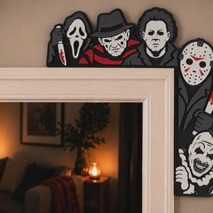 Könnte beinhalten: Ein dekoratives Tür-Eckschild mit fünf Horrorfilm-Charakteren. Der obere Teil zeigt Ghostface, Freddy Krueger und Michael Myers. Der seitliche Teil zeigt Jason Voorhees, der eine blutige Machete über Art the Clown hält.