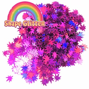 Puede incluir: Un montón de purpurina rosa, morada y azul con forma de hoja. Un arcoíris y las palabras "Shape Glitter" están en la esquina superior izquierda. La purpurina está esparcida sobre un fondo blanco.