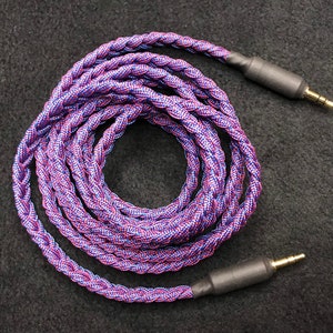 May include: A braided audio cable with a purple and blue color scheme. The cable has two 3.5mm gold-plated connectors.