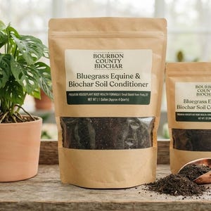 Puede incluir: Dos bolsas de papel marrón de Bourbon County Biochar Bluegrass Equine & Biochar Soil Conditioner. La bolsa grande es de 1 galón, la pequeña de 1 cuarto. Una pala de color cobre está junto a las bolsas con un pequeño montón de tierra oscura.