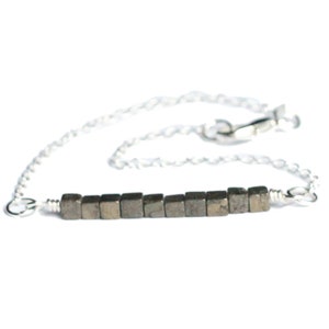 May include: A silver chain bracelet with a row of small, square pyrite beads.