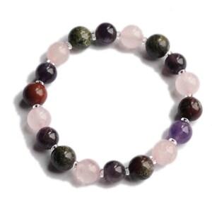 May include: A bracelet made with round, multi-colored gemstone beads. The beads are pink, red, purple, and green.