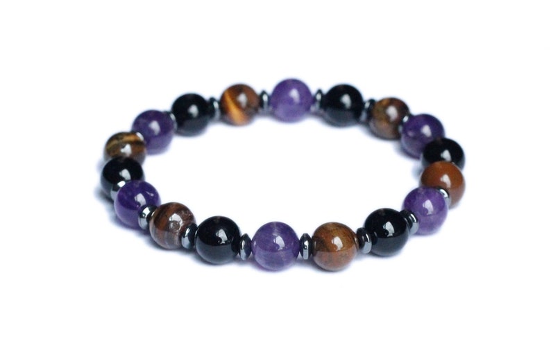 May include: A beaded bracelet with purple, brown, and black beads. The bracelet is made of amethyst, tiger's eye, and black onyx.