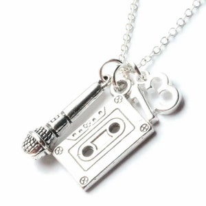 Può includere: Collana d'argento con ciondolo a forma di cassetta, microfono e numero 13.