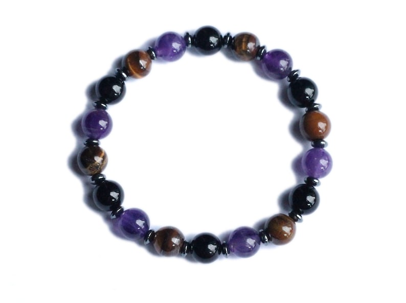 May include: A beaded bracelet with amethyst, tiger's eye, and black onyx beads. The bracelet is made with silver-toned metal spacers.