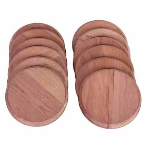 May include: Two stacks of round, wooden coasters. Each coaster is a light brown color with visible wood grain. The coasters are arranged in a fan-like pattern, showcasing their circular shape and natural wood texture.