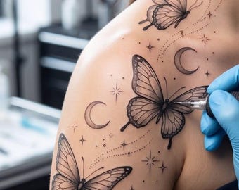 Könnte beinhalten: Ein schwarzes Tattoo-Design auf einer Schulter mit drei Schmetterlingen, drei Mondsicheln sowie verschiedenen kleinen Sternen und gepunkteten Linien. Das Tattoo wird mit einer professionellen Maschine gestochen.