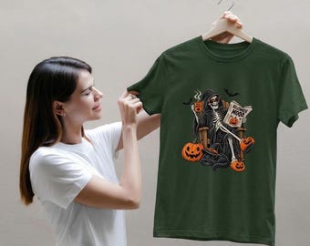 Könnte beinhalten: Ein dunkelolivgrünes Kurzarm-T-Shirt mit einer Grafik eines Skeletts mit Sonnenbrille, das in einem Stuhl sitzt und eine Tasse sowie eine Zeitung mit der Aufschrift "HALLOWEEN MOOD" hält. Das Design zeigt zwei orangefarbene Kürbisse und eine schwarze Katze.