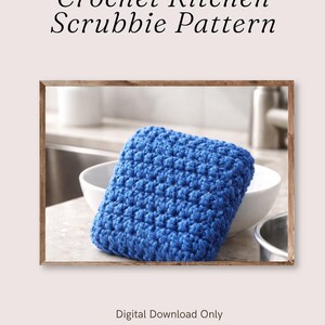 May include: A square, blue crochet kitchen scrubbie with a textured, knotted surface. The image includes the text 'Crochet Kitchen Scrubbie Pattern' at the top and 'Digital Download Only' at the bottom, presented in a simple, clean font style.