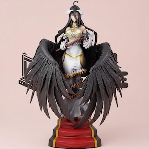 May include: A detailed anime-style figurine of a character with long black hair, white horns, and large black feathered wings. The figure wears a white dress with gold trim and holds a brown staff, standing on a red and black tiered base.