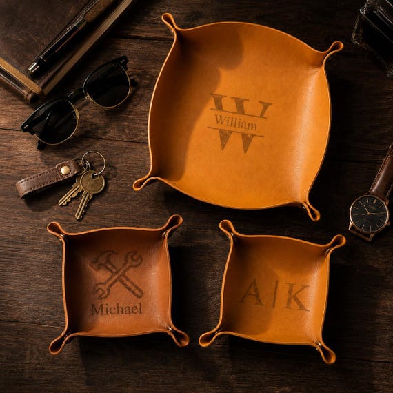Full-grain leather valet tray custom-stamped with a name or initials — the kind of desk/nightstand anchor that makes a guy's EDC dump feel intentional, not chaotic.