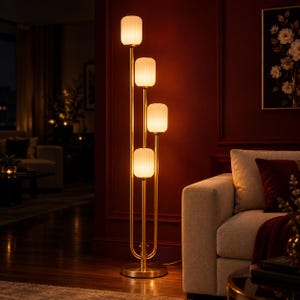 May include: A floor lamp with a gold-toned metal frame and four vertical stems of varying heights. Each stem is topped with a cylindrical, vertically ribbed white glass shade that emits a warm, soft glow, anchored by a circular base.