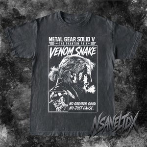 May include: A charcoal grey t-shirt featuring a white graphic print of Venom Snake from Metal Gear Solid V: The Phantom Pain. The design includes the character's profile, a smaller portrait, and the text: METAL GEAR SOLID V, THE PHANTOM PAIN, VENOM SNAKE, NO GREATER GOOD. NO JUST CAUSE.