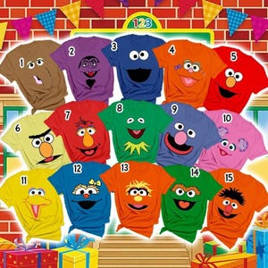 Puede incluir: Una colección de quince camisetas de manga corta, cada una con el rostro de un personaje diferente de Barrio Sésamo impreso en la parte delantera. Las camisetas se muestran en varios colores, incluyendo marrón, morado, azul, naranja, rojo, amarillo, verde y rosa.