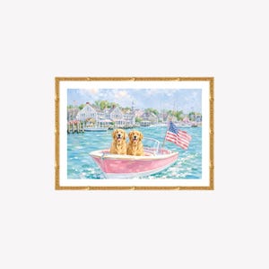 May include: A framed art print depicting two golden retriever dogs sitting in a pink motorboat on blue water. An American flag is attached to the boat. In the background, there is a coastal town with houses and boats under a light blue sky.