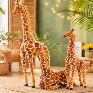 May include: Three plush giraffe toys with brown and white spotted patterns. One tall giraffe stands on the left, a second giraffe sits in the center, and a third smaller giraffe stands on the right. Each has a long neck and small horns.