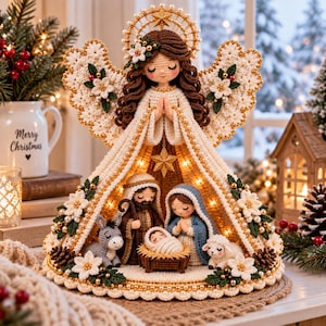 May include: A crochet nativity scene featuring a large angel with brown hair and white wings standing over a small manger with a baby, a man, a woman, a donkey, and a sheep. The angel is decorated with white flowers, pearls, and a gold star halo.
