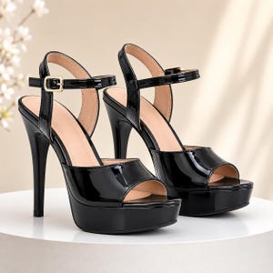 May include: A pair of black patent leather platform sandals featuring an open-toe design, a high stiletto heel, and an adjustable ankle strap with a gold-toned metal buckle. The interior of the shoes is lined in a light beige material.