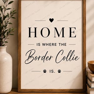 May include: A rectangular wall art print in a dark wood frame featuring the black text HOME IS WHERE THE Border Collie IS. The design includes a small black heart above the word HOME and two black paw prints flanking the word IS at the bottom.