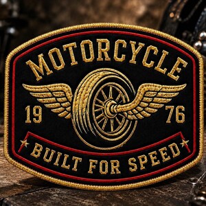 May include: A rectangular embroidered patch with rounded corners featuring a black background, gold borders, and red accents. It displays a central winged tire, the text MOTORCYCLE, the numbers 19 and 76, and the text BUILT FOR SPEED.