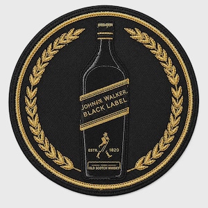 Puede incluir: Un parche circular bordado en negro que presenta una botella de Johnnie Walker Black Label cosida en hilo dorado. El diseño incluye un borde de corona de laurel dorada, el texto Johnnie Walker Black Label y el logo de la figura que camina.