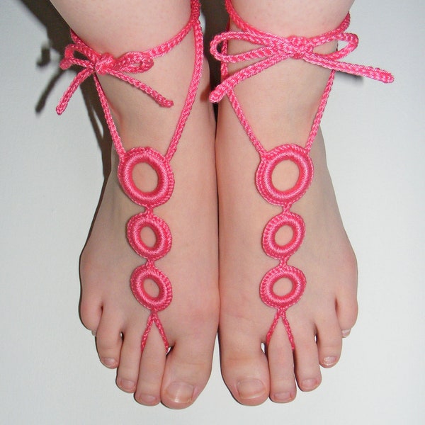 A pair of Crochet Barefoot Summer Beach Sandals in Bright Pink Triple Circle Design