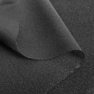 Peut inclure: Gros plan sur un tissu noir à armure texturée. Le tissu est plié sur lui-même, créant un effet de drapé doux.