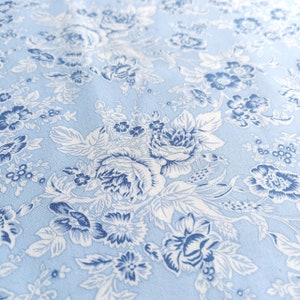 Tessuto popeline di cotone 100% stampato floreale tonale azzurro - Fiori bianchi e blu scuro su sfondo blu